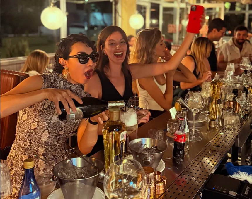 Clientes brindando con vino en la barra de Loco Wine